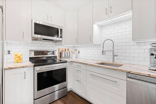 3850 Plymouth Blvd Unit 212, Plymouth, MN 55446 - kitchen with appliances with stainless steel finishes, white cabinets, backsplash, light stone countertops, and dark wood finished floors