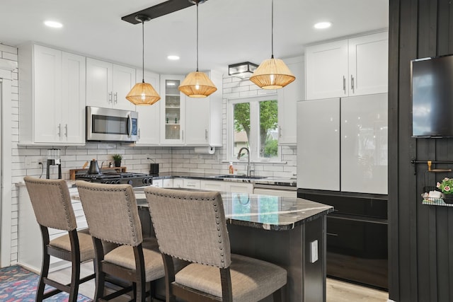 3940 Virginia Ave N, New Hope, MN 55427 - kitchen with stainless steel microwave, tasteful backsplash, white cabinets, and recessed lighting