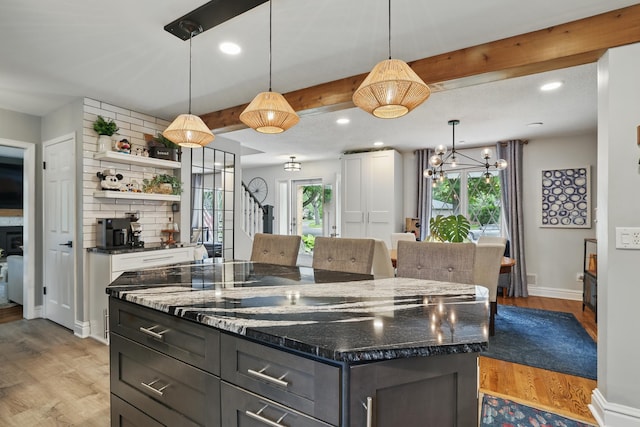 3940 Virginia Ave N, New Hope, MN 55427 - kitchen with open shelves, a center island, light wood-style floors, dark stone counters, and beam ceiling