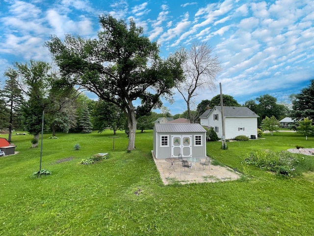 605 13th St, Mountain Lake, MN 56159 - view of grassy yard featuring an outdoor structure and a patio