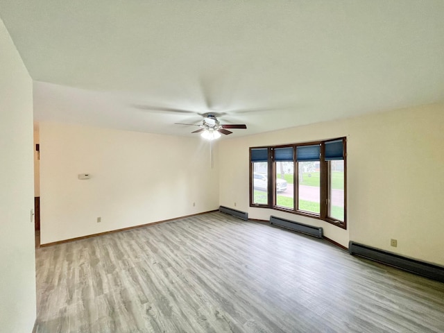 605 13th St, Mountain Lake, MN 56159 - unfurnished room with wood finished floors, a ceiling fan, baseboard heating, and baseboards