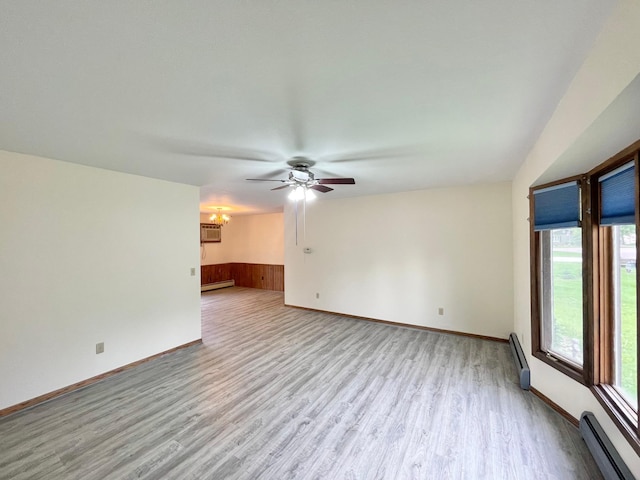 605 13th St, Mountain Lake, MN 56159 - unfurnished living room featuring a baseboard heating unit, wood finished floors, ceiling fan, and a chandelier
