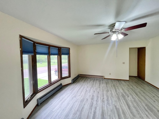 605 13th St, Mountain Lake, MN 56159 - unfurnished room featuring a baseboard heating unit, light wood-type flooring, ceiling fan, and baseboards