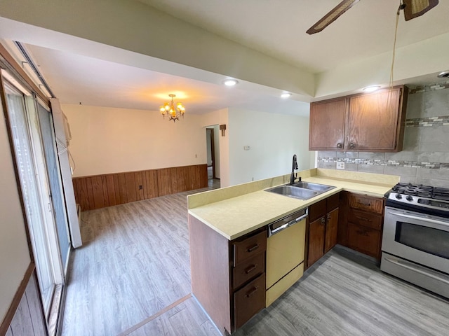 605 13th St, Mountain Lake, MN 56159 - kitchen featuring appliances with stainless steel finishes, a sink, light wood-style floors, a peninsula, and a chandelier