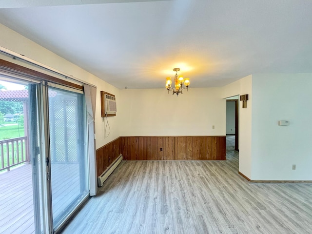 605 13th St, Mountain Lake, MN 56159 - unfurnished room featuring a baseboard radiator, light wood-style flooring, a chandelier, a wall mounted AC, and wainscoting