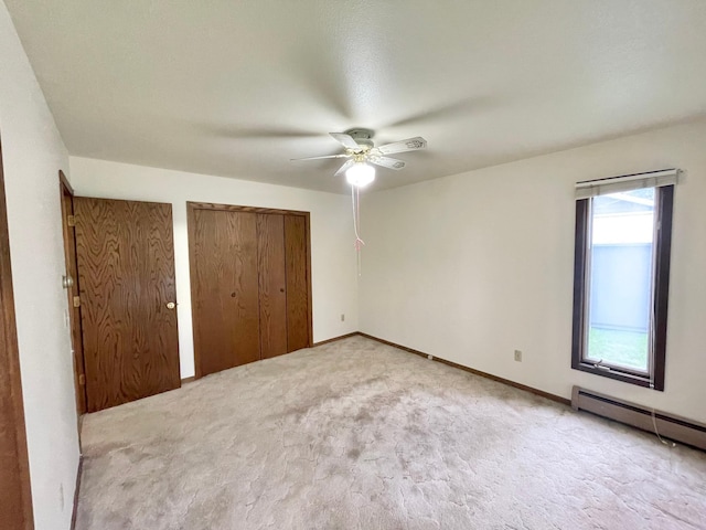 605 13th St, Mountain Lake, MN 56159 - unfurnished bedroom with a baseboard heating unit, carpet, two closets, ceiling fan, and baseboards