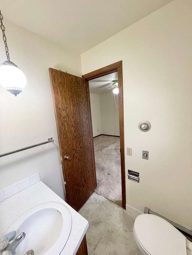 605 13th St, Mountain Lake, MN 56159 - bathroom with vanity, toilet, and baseboards