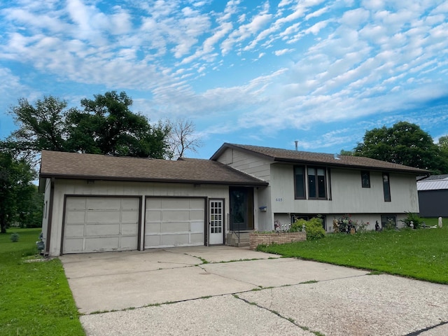 605 13th St, Mountain Lake, MN 56159 - tri-level home with concrete driveway, an attached garage, and a front lawn
