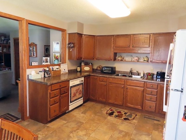 1223 Elizabeth Ave N, Thief River Falls, MN 56701 - kitchen with freestanding refrigerator, a sink, brown cabinetry, and wall oven