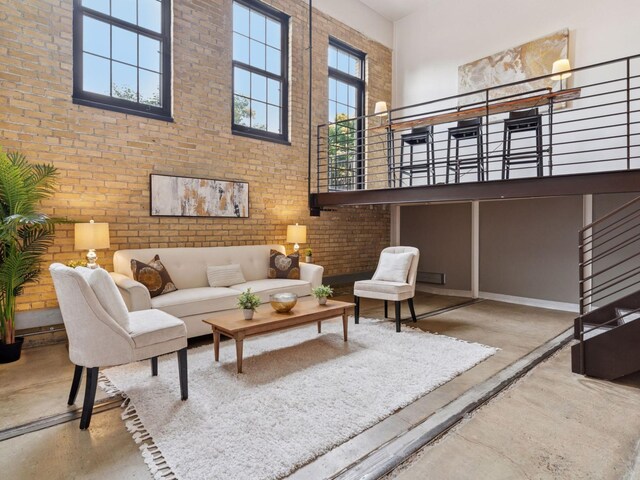 730 Stinson Blvd Unit 106, Minneapolis, MN 55413 - living area featuring a towering ceiling, brick wall, and finished concrete flooring