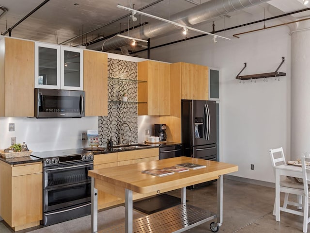 730 Stinson Blvd Unit 106, Minneapolis, MN 55413 - kitchen featuring appliances with stainless steel finishes, dark countertops, tasteful backsplash, concrete flooring, and light brown cabinetry