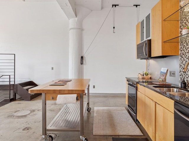730 Stinson Blvd Unit 106, Minneapolis, MN 55413 - kitchen with appliances with stainless steel finishes, dark stone counters, ornate columns, light brown cabinetry, and concrete flooring
