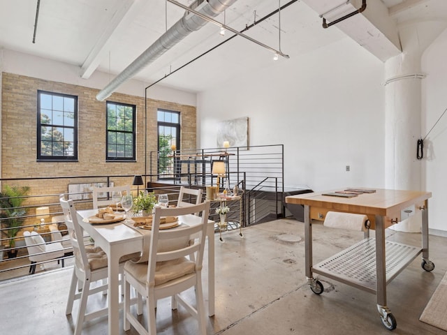 730 Stinson Blvd Unit 106, Minneapolis, MN 55413 - dining room with concrete flooring, brick wall, and beamed ceiling