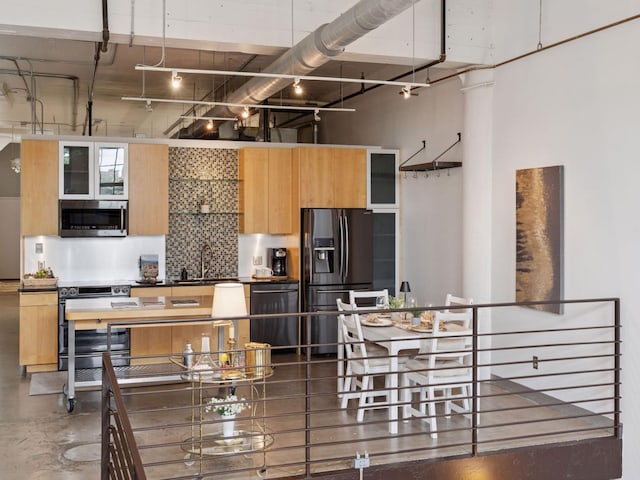 730 Stinson Blvd Unit 106, Minneapolis, MN 55413 - kitchen with appliances with stainless steel finishes, a towering ceiling, backsplash, glass insert cabinets, and rail lighting