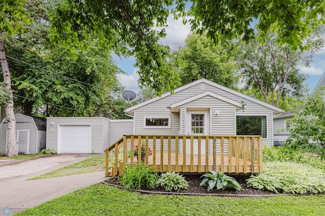 1019 3rd Ave N, Moorhead, MN 56560 - view of front of house featuring driveway, a deck, and a storage shed