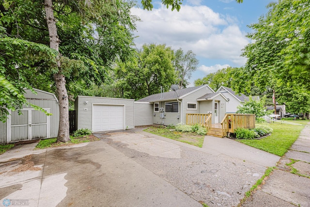 1019 3rd Ave N, Moorhead, MN 56560 - view of front of property with driveway, a storage shed, a deck, and a garage