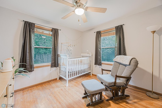 1019 3rd Ave N, Moorhead, MN 56560 - bedroom with light wood-style flooring, a crib, and ceiling fan