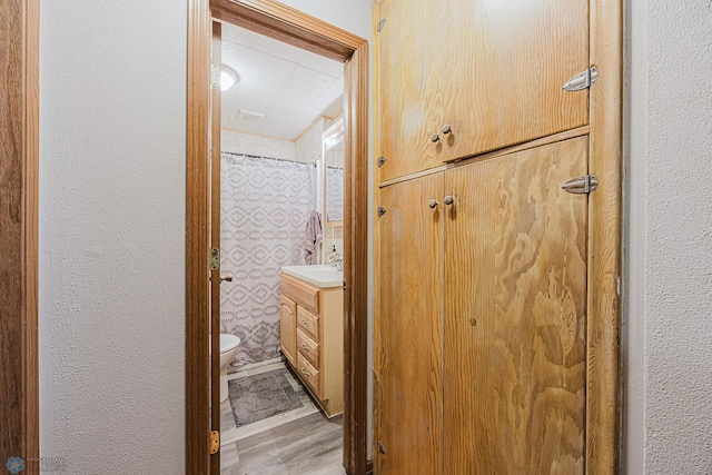 1019 3rd Ave N, Moorhead, MN 56560 - full bath with vanity, wood finished floors, a textured wall, and a shower with curtain