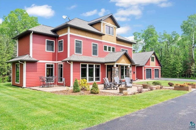 1753 Old N Shore Rd, Duluth Twp, MN 55804 - view of front of property with a patio area, a front yard, asphalt driveway, an attached garage, and a shingled roof