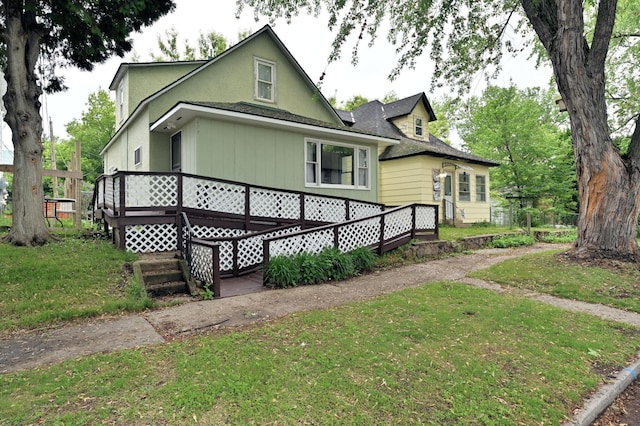 409 3rd St, Bovey, MN 55709 - view of side of home with a deck and a lawn