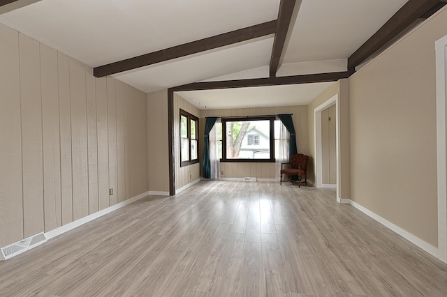 409 3rd St, Bovey, MN 55709 - unfurnished living room featuring light wood-style flooring, wood walls, and baseboards