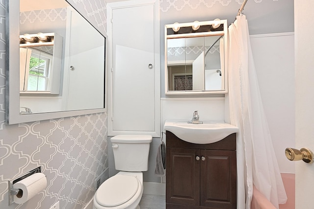 409 3rd St, Bovey, MN 55709 - bathroom featuring toilet, vanity, and shower / bathtub combination with curtain
