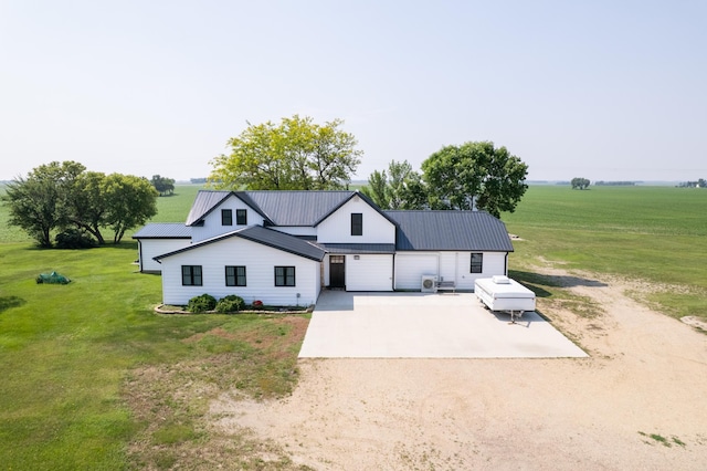 2977 State Highway 68, Marshall, MN 56258 - modern farmhouse with dirt driveway, a front yard, an attached garage, a metal roof, and a view of rural / pastoral area