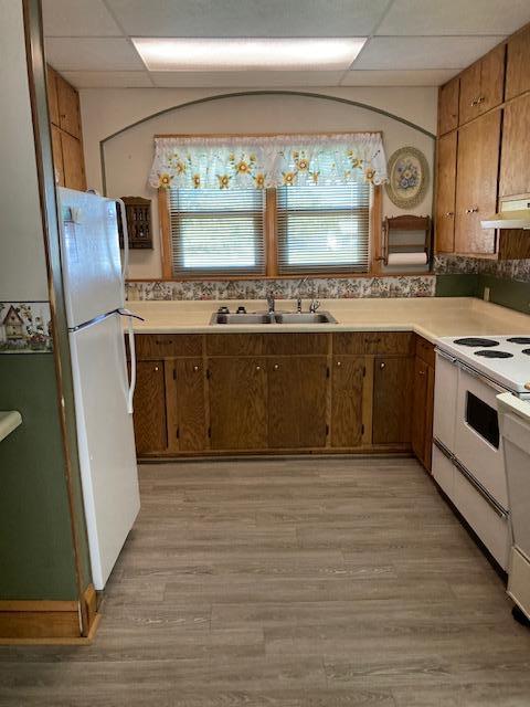 201 Cherry St, Lowry, MN 56349 - kitchen with white appliances, a sink, under cabinet range hood, and light countertops