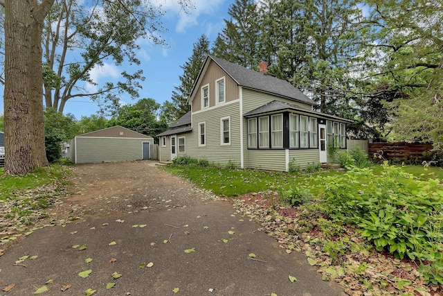 505 Riverside Ave N, Sartell, MN 56377 - view of front of house with roof with shingles, a sunroom, an outdoor structure, and driveway