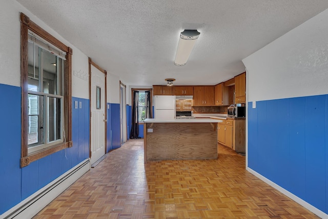 505 Riverside Ave N, Sartell, MN 56377 - kitchen featuring baseboard heating, freestanding refrigerator, stainless steel microwave, a textured ceiling, and light countertops