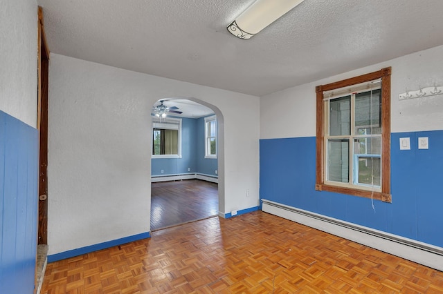505 Riverside Ave N, Sartell, MN 56377 - unfurnished room with baseboard heating, a textured ceiling, arched walkways, and a ceiling fan