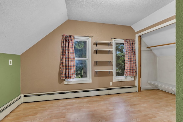 505 Riverside Ave N, Sartell, MN 56377 - bonus room with vaulted ceiling, wood finished floors, a textured ceiling, and a baseboard heating unit