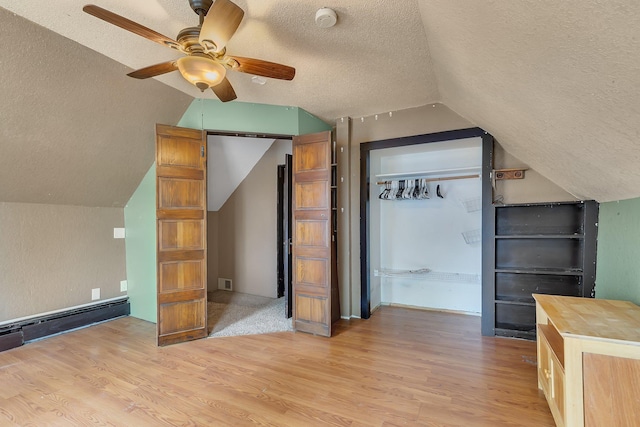 505 Riverside Ave N, Sartell, MN 56377 - additional living space featuring a textured ceiling, light wood-style floors, lofted ceiling, a ceiling fan, and baseboard heating