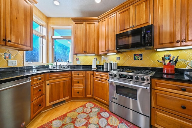 14802 Margaret Pl, Minnetonka, MN 55345 - kitchen featuring appliances with stainless steel finishes, light wood finished floors, brown cabinets, a textured ceiling, and recessed lighting