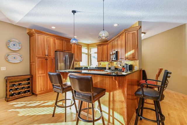 14802 Margaret Pl, Minnetonka, MN 55345 - kitchen with stainless steel appliances, brown cabinetry, a peninsula, a breakfast bar area, and recessed lighting