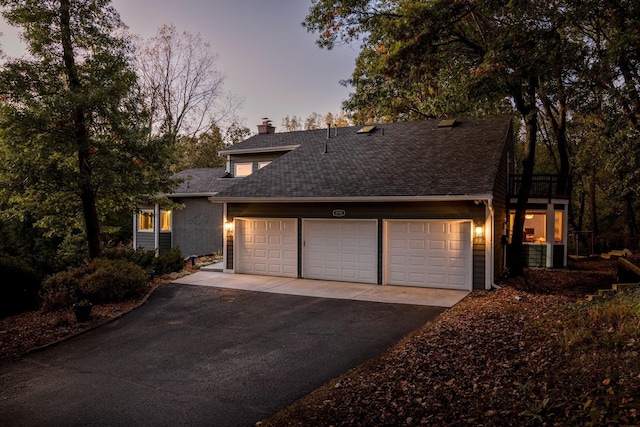 8155 134th St W, Apple Valley, MN 55124 - view of front of home featuring asphalt driveway, a garage, a chimney, and a shingled roof