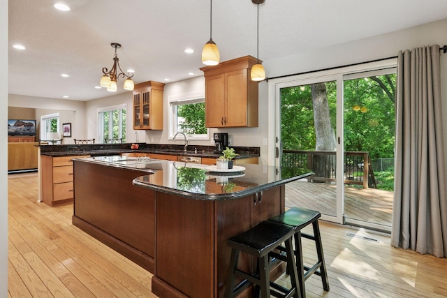 8155 134th St W, Apple Valley, MN 55124 - kitchen with a peninsula, light wood-type flooring, a kitchen island, glass insert cabinets, and recessed lighting