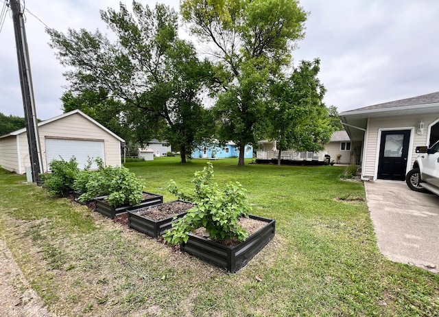 211 5th St NE, Barnesville, MN 56514 - view of grassy yard with a garden, a garage, and an outbuilding