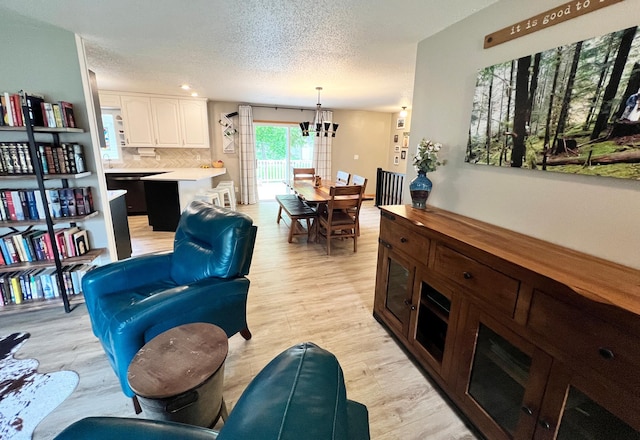 211 5th St NE, Barnesville, MN 56514 - living area featuring a chandelier, a textured ceiling, and light wood-style flooring