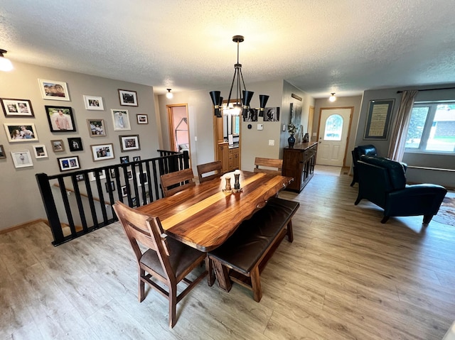 211 5th St NE, Barnesville, MN 56514 - dining space with a textured ceiling, light wood finished floors, and baseboards