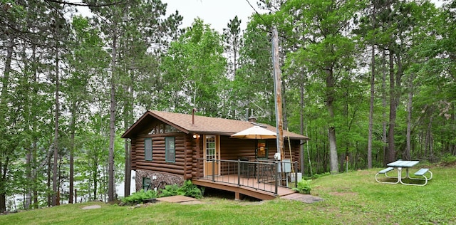 3938 State Road 77, Swiss Twp, WI 54830 - view of front of house with log siding, a front yard, a wooden deck, and a forest view