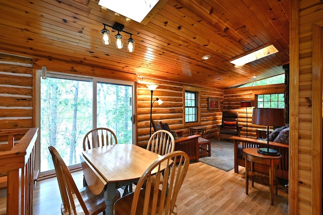 3938 State Road 77, Swiss Twp, WI 54830 - dining room featuring a skylight, vaulted ceiling, wooden ceiling, rustic walls, and light wood-style flooring