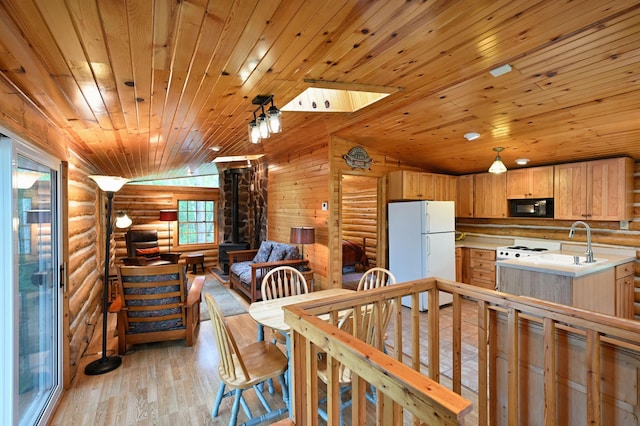 3938 State Road 77, Swiss Twp, WI 54830 - kitchen with freestanding refrigerator, black microwave, log walls, lofted ceiling, and light countertops