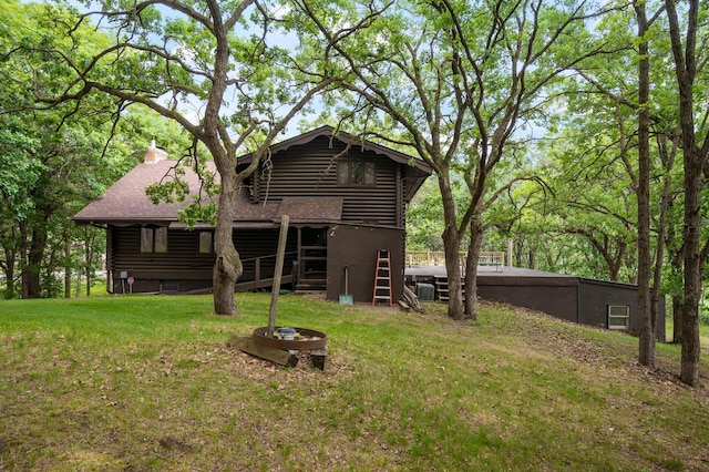 21750 Elk Lake Rd NW, Elk River, MN 55330 - rear view of house with log exterior, a lawn, roof with shingles, and a chimney