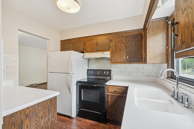 7007 Portland Ave, Richfield, MN 55423 - kitchen featuring black electric range oven, freestanding refrigerator, a sink, under cabinet range hood, and light countertops