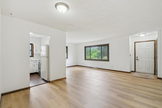 7007 Portland Ave, Richfield, MN 55423 - unfurnished living room with light wood-style flooring and baseboards