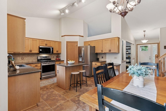 989 Coneflower Ct, Eagan, MN 55123 - kitchen with appliances with stainless steel finishes, a center island, decorative backsplash, a chandelier, and high vaulted ceiling