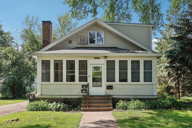 1384 Midway Pkwy, Saint Paul, MN 55108 - view of front of home featuring entry steps, a chimney, a shingled roof, and a sunroom