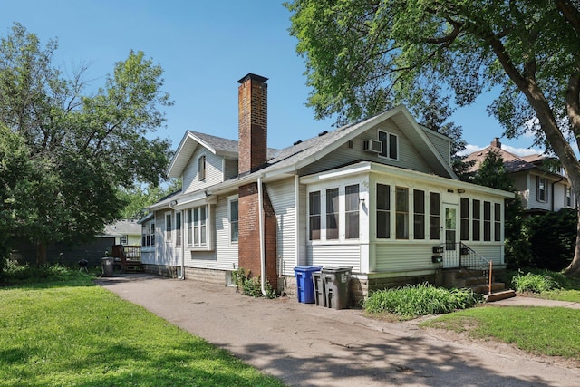 1384 Midway Pkwy, Saint Paul, MN 55108 - view of front facade featuring a chimney, a sunroom, a front yard, and entry steps