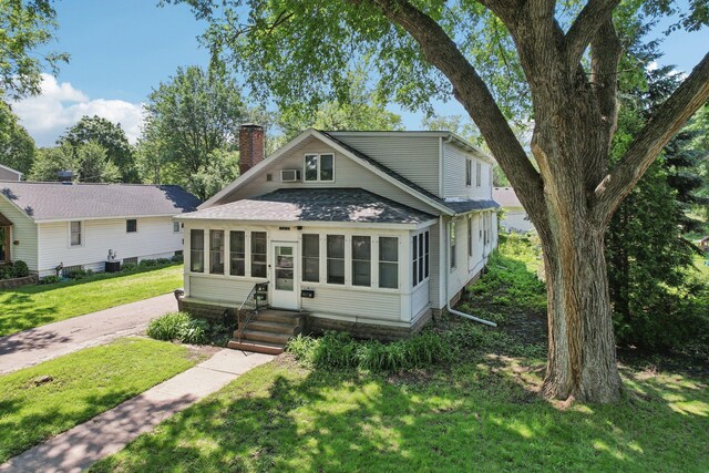 1384 Midway Pkwy, Saint Paul, MN 55108 - view of front of home with a shingled roof, a chimney, a front yard, entry steps, and a sunroom